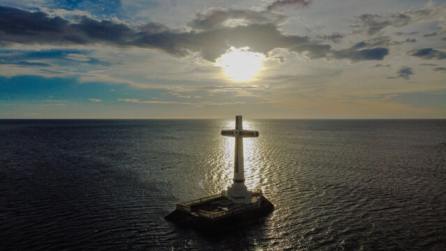 Sunken cemetery cross standing in camiguin sea at sunset