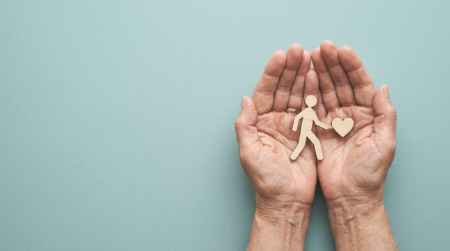 Senior hands holding a wooden running figure and a heart representing elderly exercise routine, cardiovascular health care, and active aging lifestyle.
