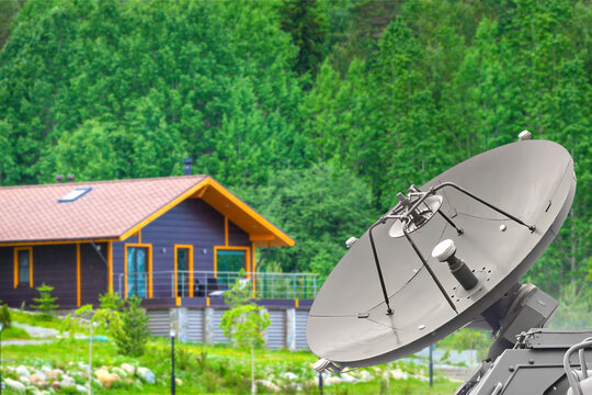 Satellite internet. Satellite dish provides broadband internet connectivity for a rural home, enabling remote communication, digital services, smart home technology and teleworking.