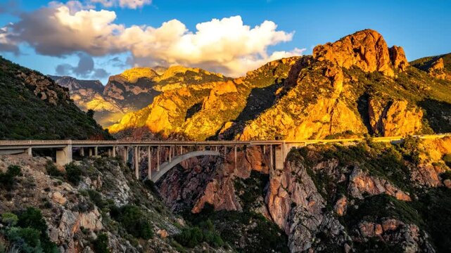 Concrete arch bridge spanning a deep mountain valley.
