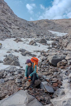 She takes off her crampons on the glaciers edge