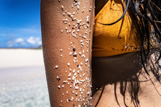 Her arm covered in beach sand