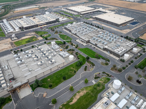 Aerial view of the Vantage Data Centers facility featuring large industrial buildings with rooftop cooling units, paved access roads, and landscaped green spaces in Quincy, Washington, United States.