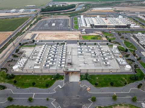 Aerial view of Vantage Data Centers featuring industrial buildings with rooftop cooling units, an electrical substation, and surrounding fields in Quincy, Washington, United States.