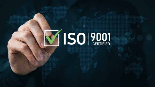Hand holding a pen pointing at iso 9001 certification