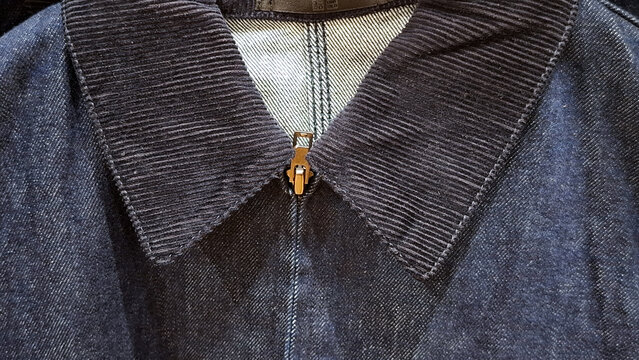 Close up view of corduroy collar and zipper detail on denim jacket outerwear
