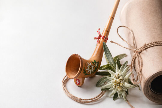 Wooden alphorn ornament, edelweiss sprig and kraft paper roll with twine, alpine gift wrapping concept