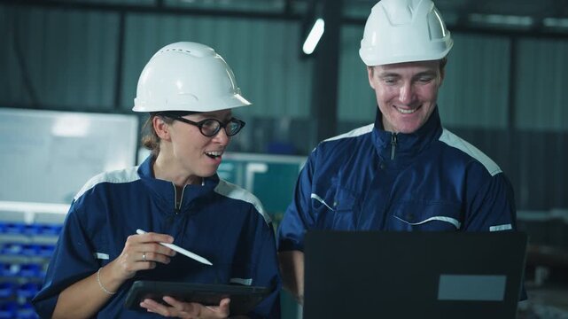 Male contractor and female engineer inspecting machine control in a modern facility. Combining expertise for automated system development.