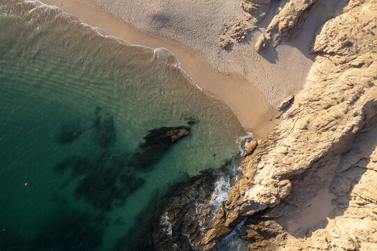 Aerial view of Chileno Bay Public Beach with turquoise waters, rocky cliffs, and sandy shoreline in Cabo San Lucas, Baja California Sur, Mexico.