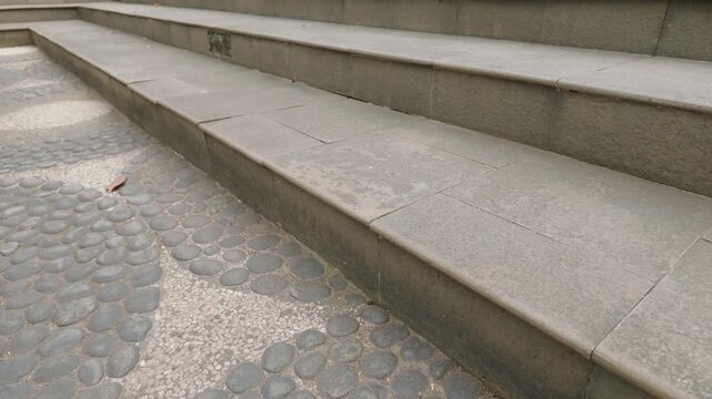 Modern concrete steps leading up with textured stone paving floor.