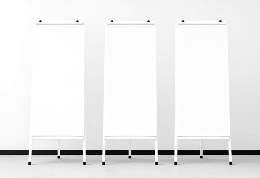 Three blank white standing presentation boards on easels ready for display in a clean room