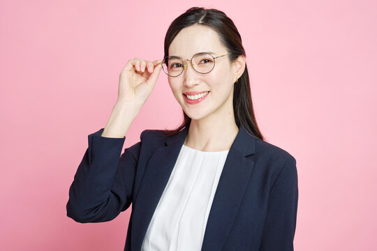 メガネに触れる笑顔のビジネスウーマン
