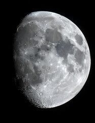 Obraz premium Detailed view of the Moons surface with craters and maria against a black sky.