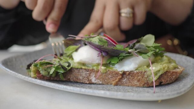 Enjoying brunch with poached eggs on toast in a cafe