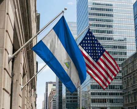 Nicaragua and United States crossed national flags waving against a blue sky, representing bilateral relations and diplomacy.