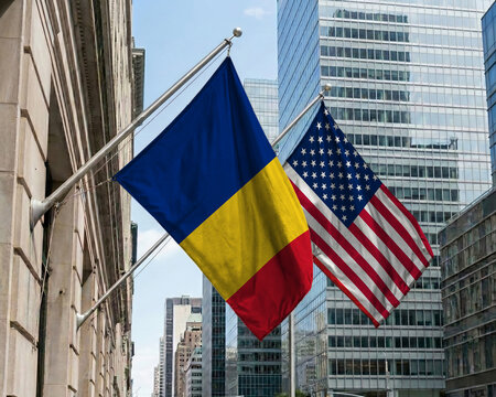 Romania and United States crossed national flags waving against a blue sky, representing bilateral relations and diplomacy.