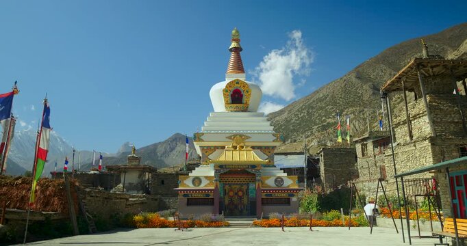 Annapurna Circuit, Manang, Nepal, Traditional Buddhist chorten stupa decorated with prayer flags in a Himalayan village