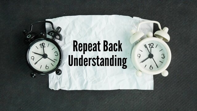 Chime clock and paper with the word Repeat back understanding. listening to someone, restating their message or instructions in your own words, and asking if you got it right.
