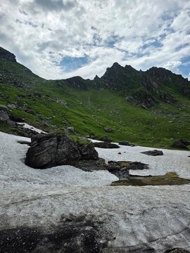 Melting summer snow field under rocky peaks in Fagaras mountains, Romania
