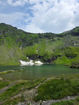 Tourist standing by the beautiful Balea glacial lake in Fagaras mountains, Romania