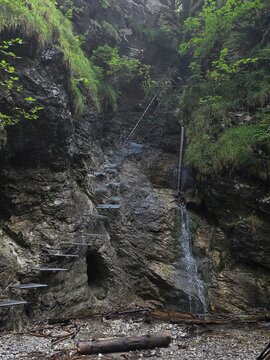 Extreme hiking trail with metal steps on a cliff next to a waterfall in Sucha Bela, Slovakia