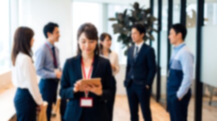 Obraz premium Business professional using a tablet during a networking event in a modern office with colleagues in the background creating an authentic professional corporate atmosphere