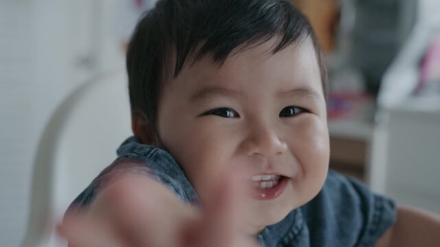 Cute Asian baby boy smiling happily and reaching hand towards camera.4K