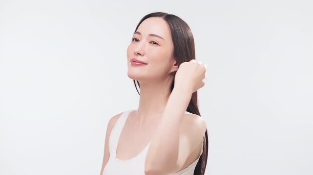 片手で髪を後ろに流してツヤを見せる日本人女性（ヘアケア・美容・横顔・澄んだ肌）