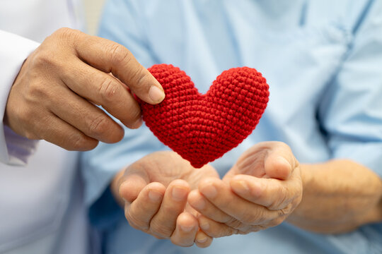 Doctor holding a red heart in hospital, healthy strong medical concept.