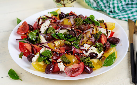 Greek Salad with Feta Cheese, Olives and Tomatoes on White Wooden Background