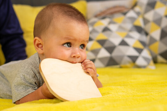 Infant Biting Wooden Activity Board On Yellow Blanket