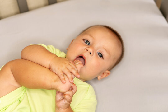Baby Boy Bringing Bare Foot Toward Mouth At Home