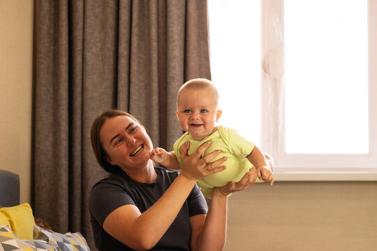 Smiling Mother Raises Happy Baby Son at Home