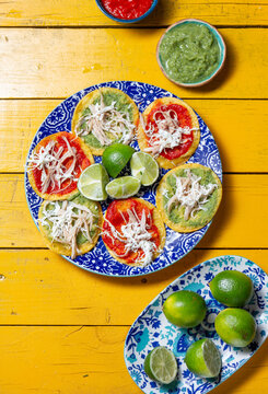 Delicious Mexican chalupas topped with chicken, served on colorful ceramics for Independence Day celebrations