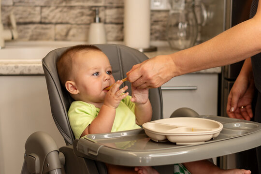 Baby Boy Reaches For Spoon During First Feeding