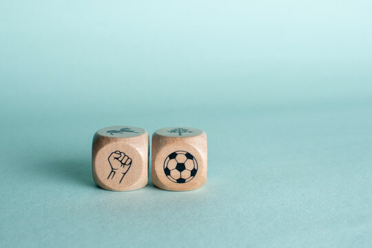 Wooden blocks with fist and soccer ball icons representing sports determination team spirit and power