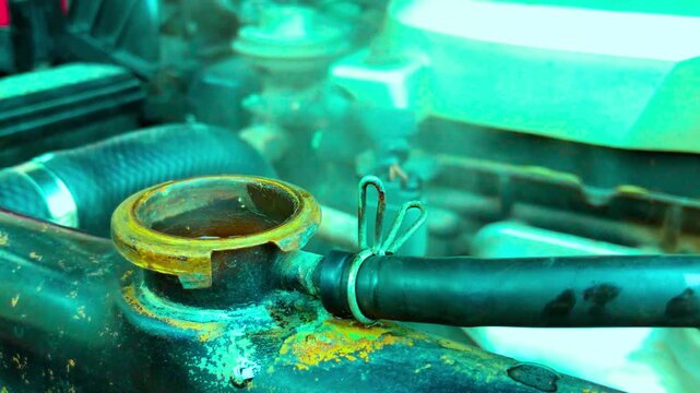 Overheating car radiator with steam rising from open cap in engine bay