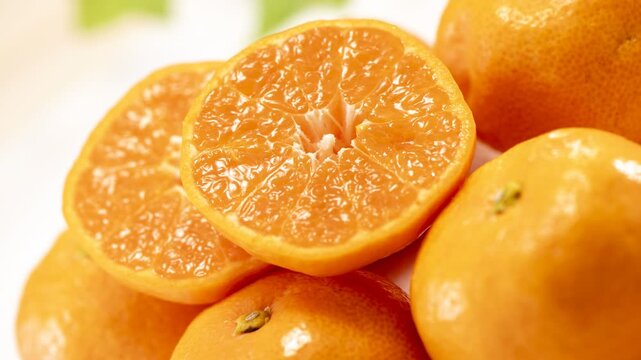 Mandarin oranges cut in half showing the juicy segments, camera zooms in and pans across the fruit
