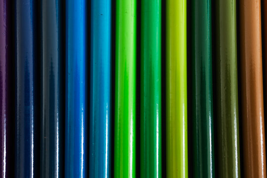 close-up of colored pencil barrels neatly lined up in colour wheel order, concept of creativity and education