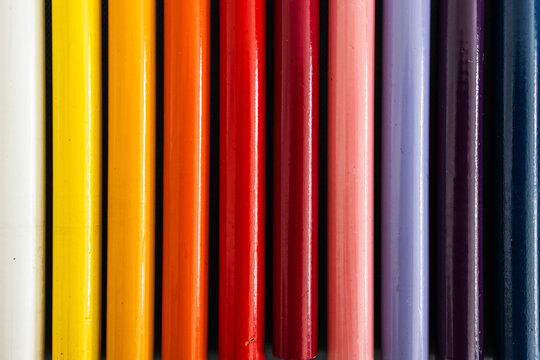 close-up of colored pencil barrels neatly lined up in colour wheel order, concept of creativity and education