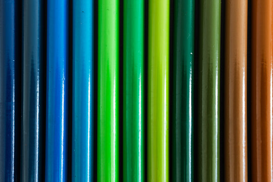 close-up of colored pencil barrels neatly lined up in colour wheel order, concept of creativity and education