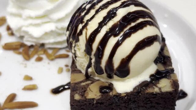 Close-up of creamy vanilla ice cream topped with rich chocolate sauce, creating an indulgent dessert with elegant presentation.