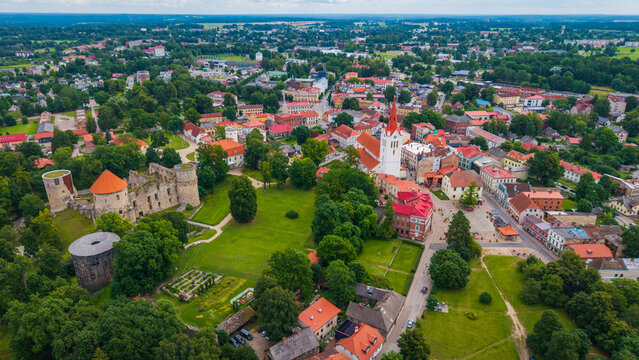 Aerial view of Cesis Castle ruins and the historic St. Johns Church surrounded by lush green parks and traditional red-roofed buildings in Cesis, Cesis Municipality, Latvia.