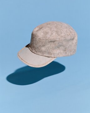 A generic wool service cap with a felt texture floating over a blue background for a military veteran recognition brochure