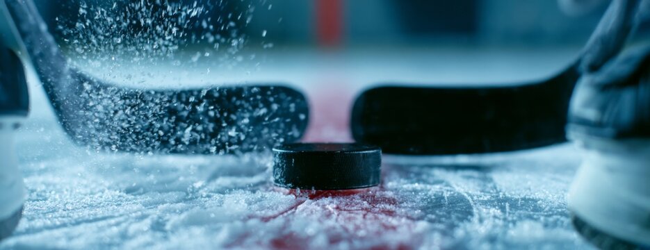 Hockey players battling for the puck on ice at a stadium  