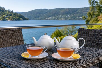Fototapeta premium Relaxing tea time on a balcony with fjord view