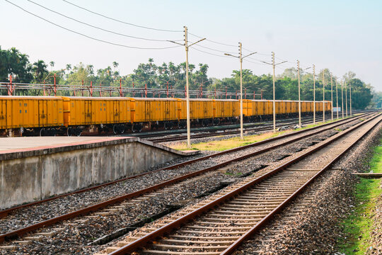 Yellow Freight Train Wagons Parked on Railway Tracks at Rural Station