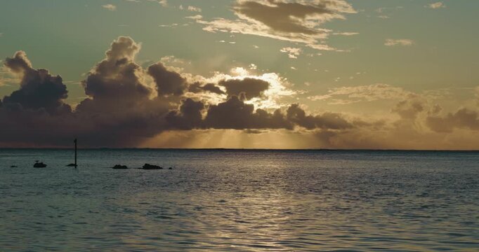 Golden sunset over calm ocean waters in Moorea