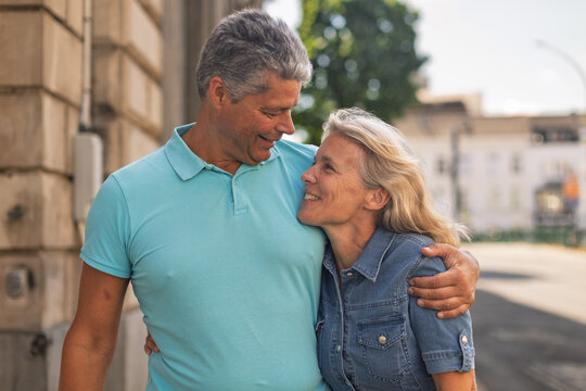 Mature couple embracing on a sunny city street