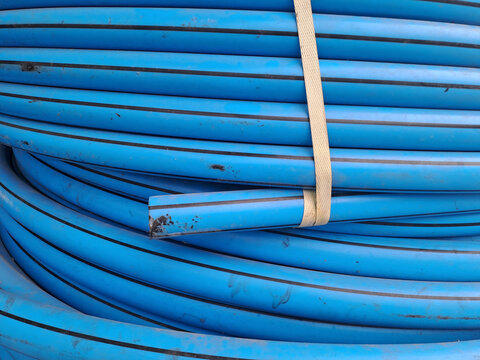 Roll of blue plastic polyethylene pipes for water supply and plumbing construction